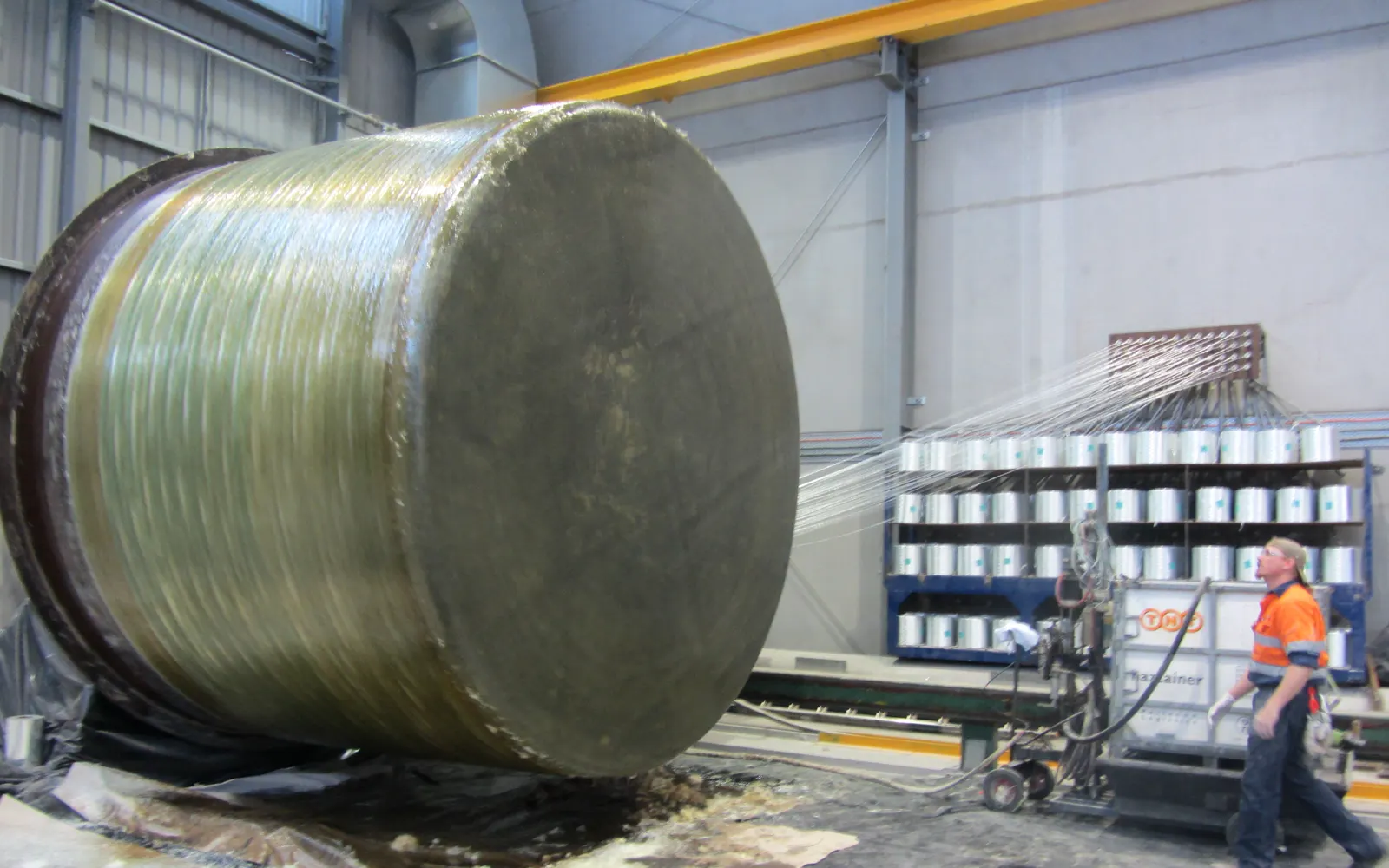 Glass-fibre rovings feeding onto a large FRP wet well shell on the filament-winding mandrel for Stone Drive, Mackay