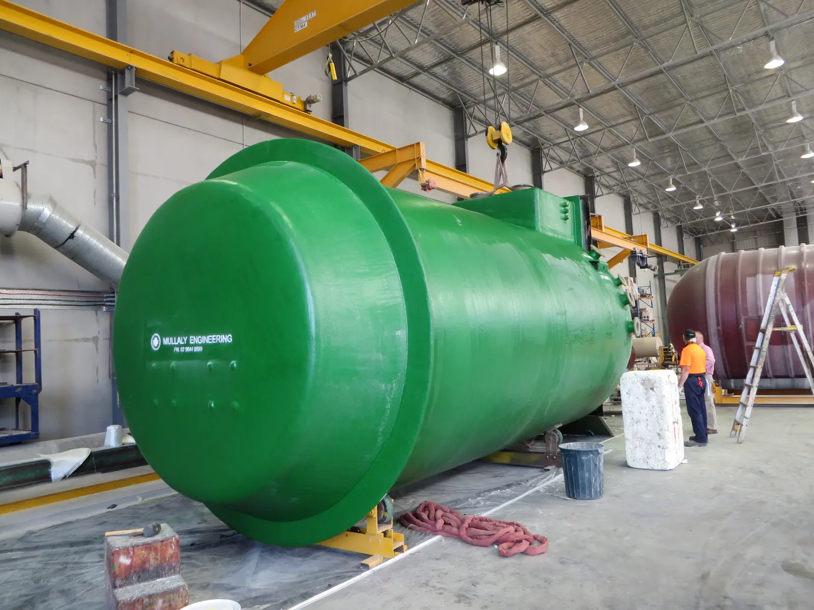 Finished green Mullaly Engineering FRP wet well on cradles in the factory awaiting client inspection